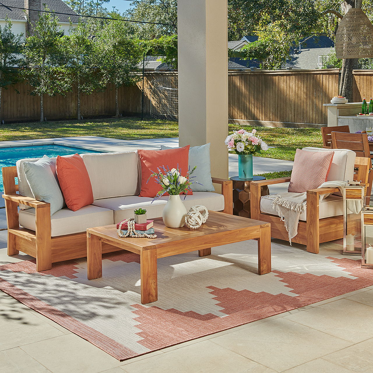 Outdoor seating area with wooden furniture, cushions, and a coffee table.