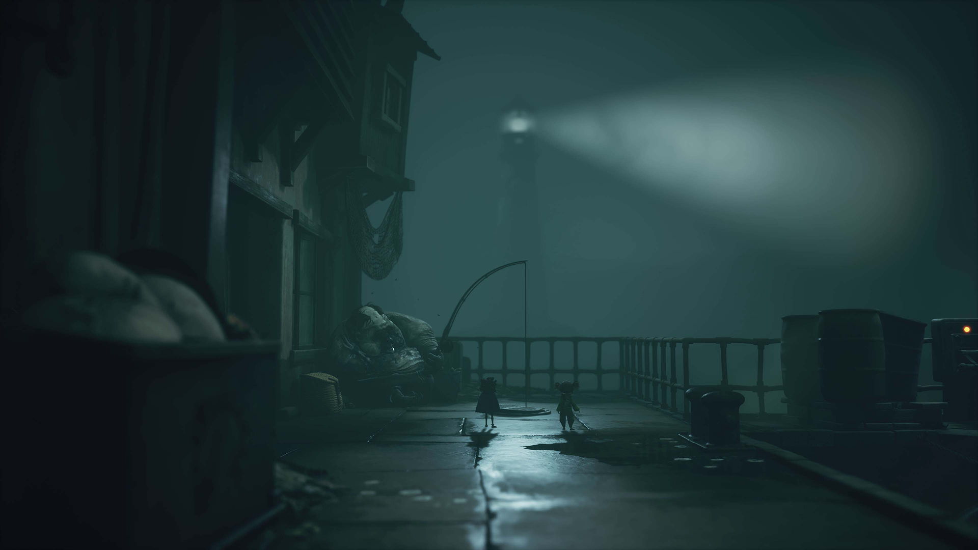 Foggy night scene with a light illuminating a deserted alleyway.