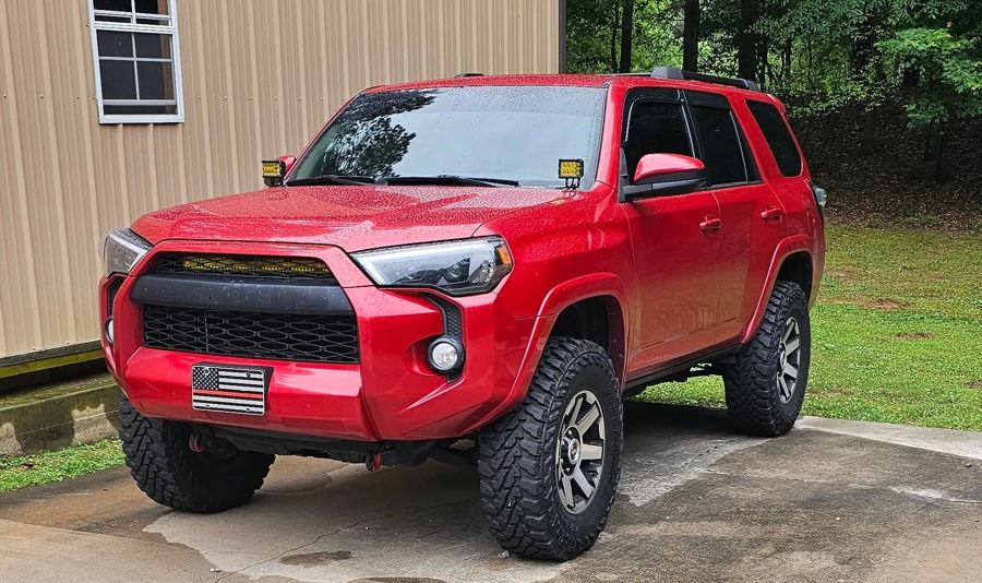 Front three-quarter Daniel's red 2015 Toyota 4Runner off-road tires grille light bar ditch lights Conductor's Special 544 Nightmare Edition dual 2-gallon tank featured customer install gallery photo 1