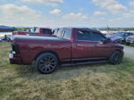Side profile of maroon Ram 1500 crew cab with aftermarket wheels and tonneau cover