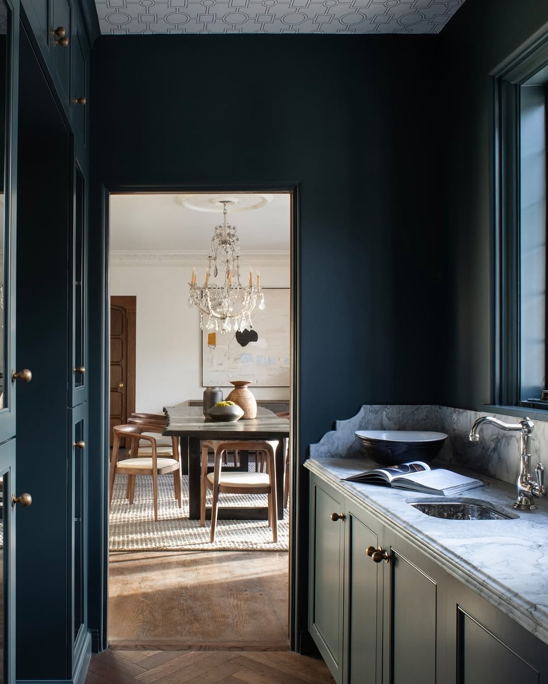 Navy and neutral kitchen design by Cooper Pacific with wood flooring, neutral decor and marble worktops