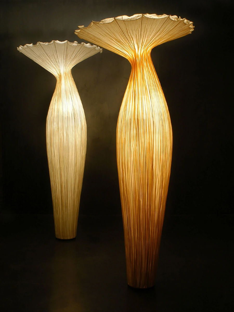 Two decorative floor lamps with unique, elongated shapes and light colors.