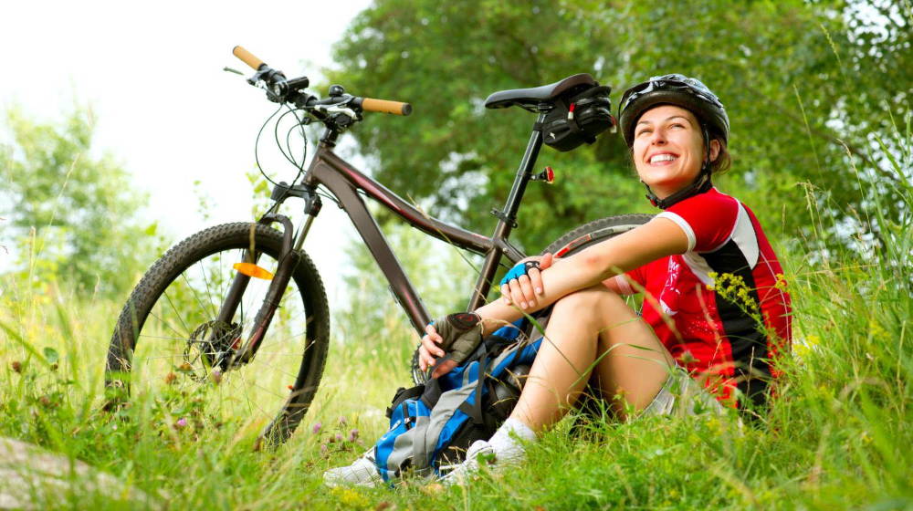 Happy Young Woman riding bicycle outside | Best Natural Antibiotics For Your Gut And Overall Health | best natural antibiotic | Featured