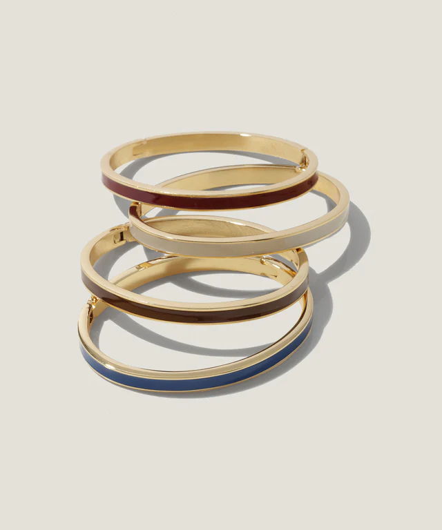 Four stacked bangles in gold and colored accents.