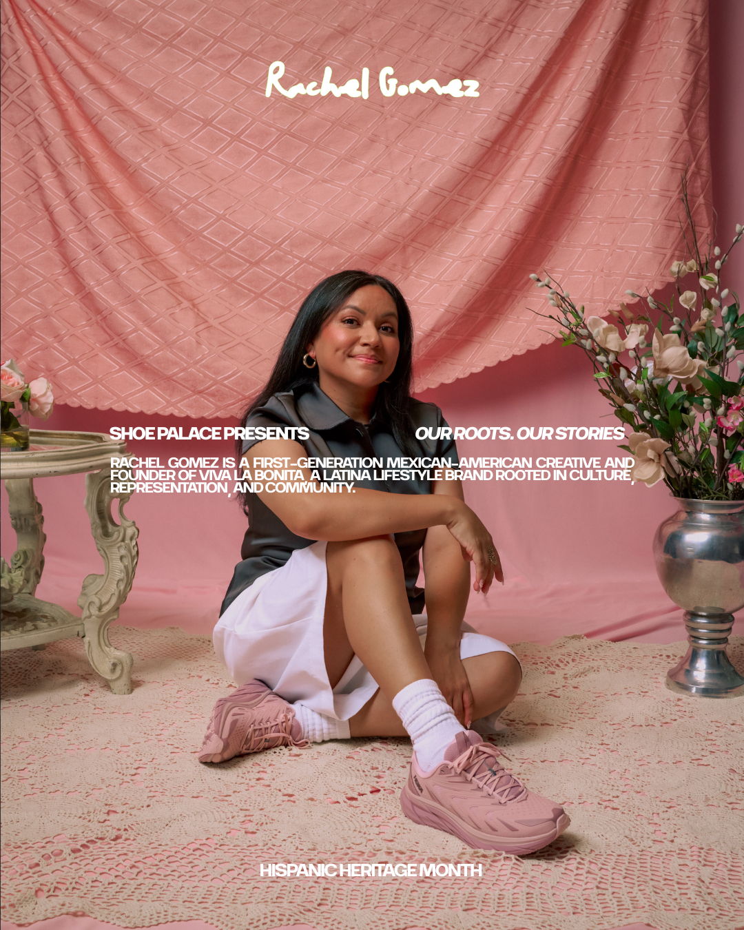 A person sitting on the floor with a pink background and flowers.