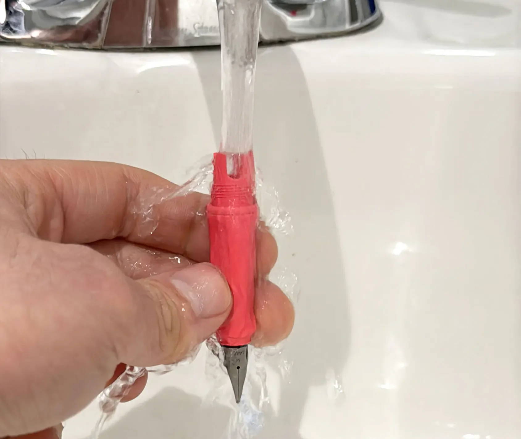 Rinsing a Lamy Safari front end section under running tap water