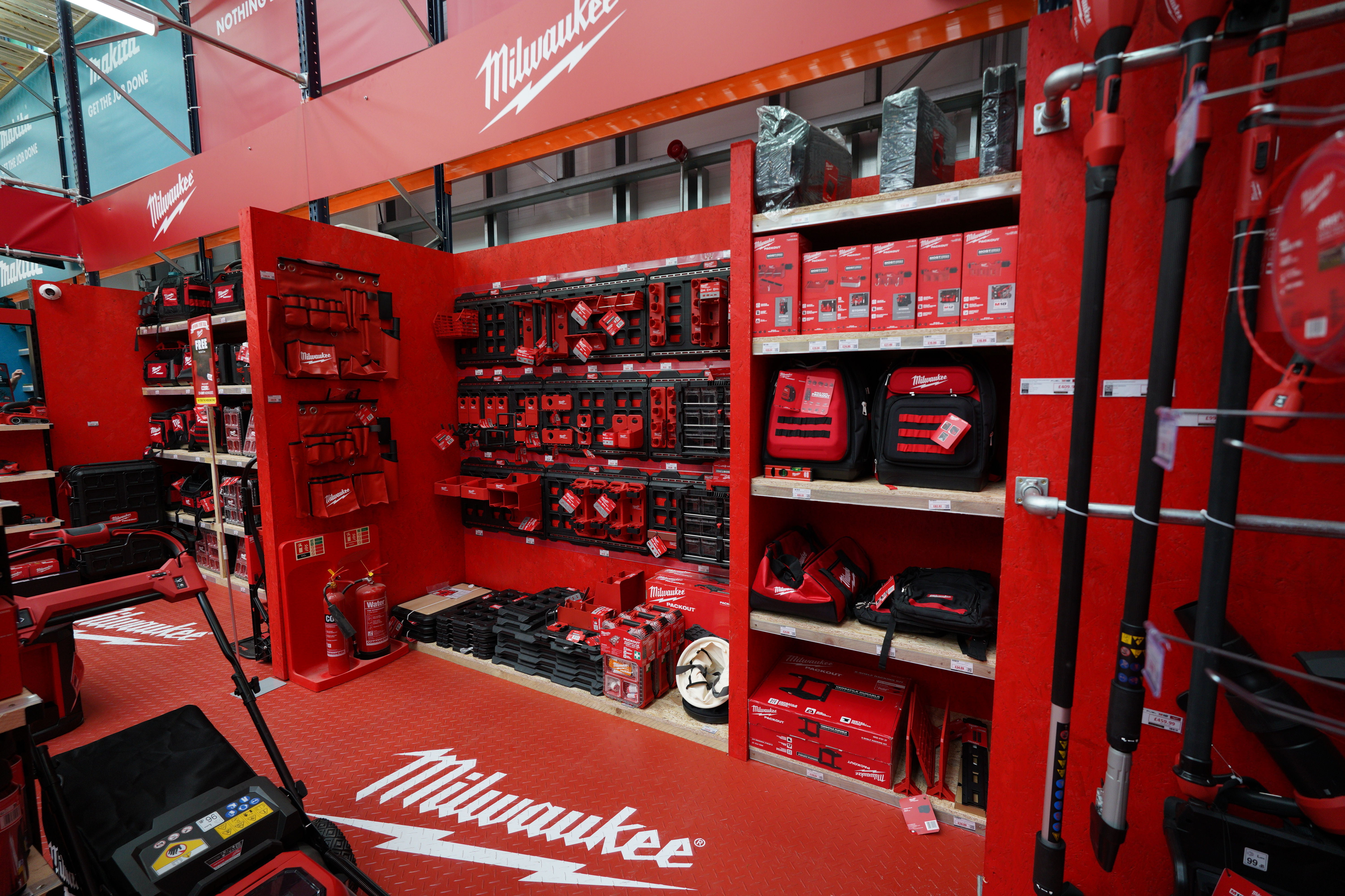 Red display of Milwaukee tools and accessories in a store setting.