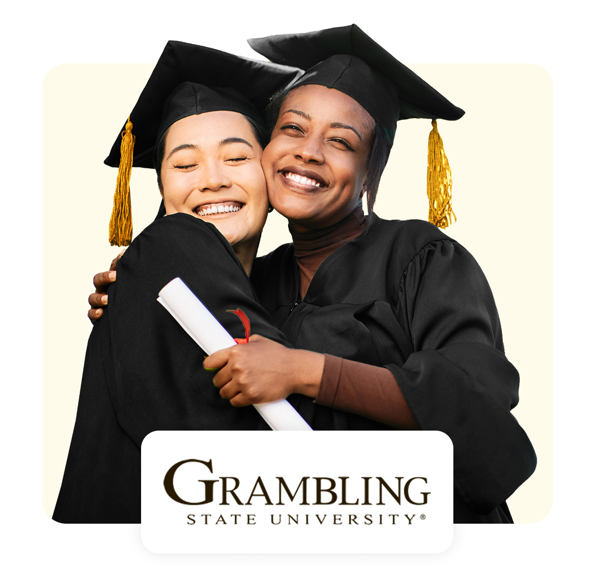 Two graduates celebrating with smiles, wearing caps and gowns, holding a diploma.