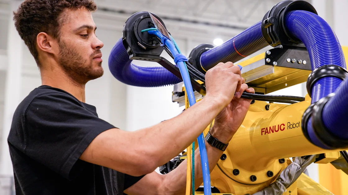 Worker installing a robotic palletizing Arm