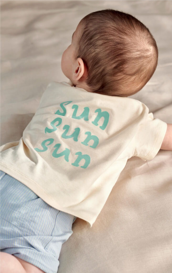 Baby lying on a bed wearing the Lobster Boucle 2pc Set with 