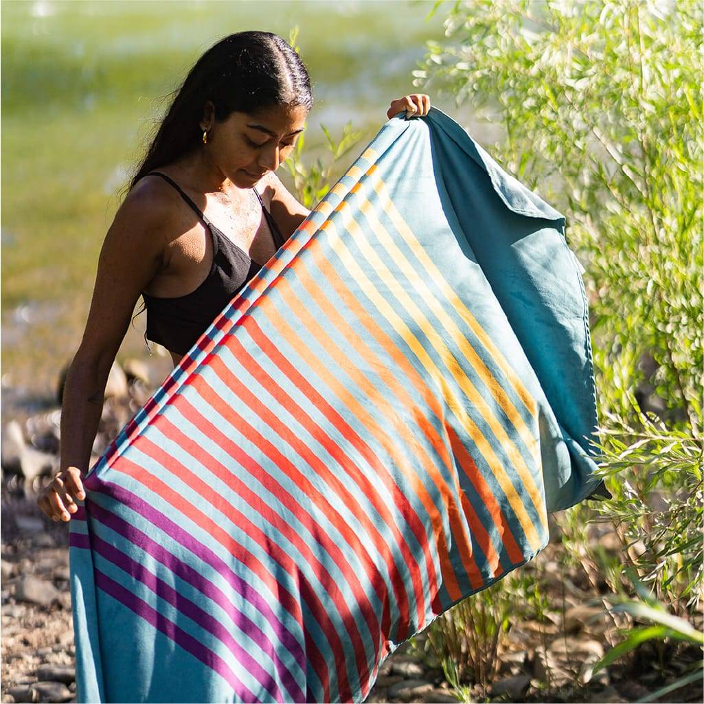 Man Shaking Out Her Everywhere Towel While At Campsite