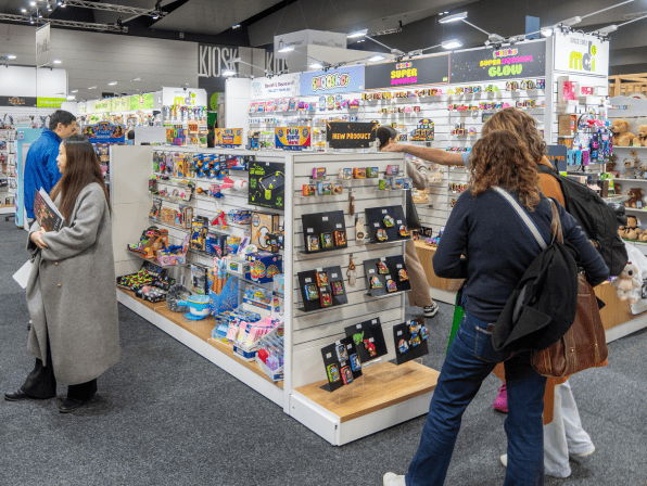 People browsing a toy display at a store or exhibition.