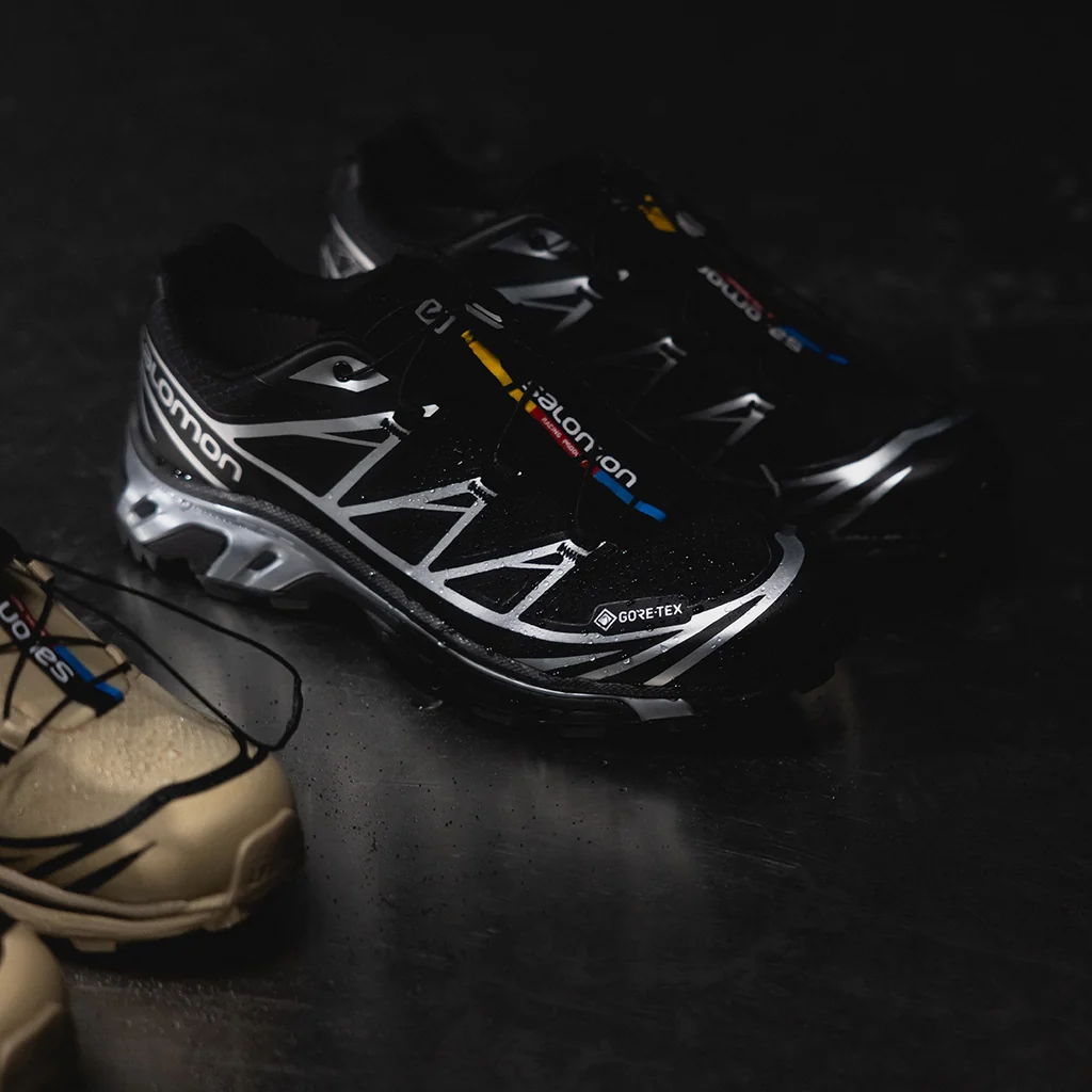 Two pairs of athletic shoes on a dark background.