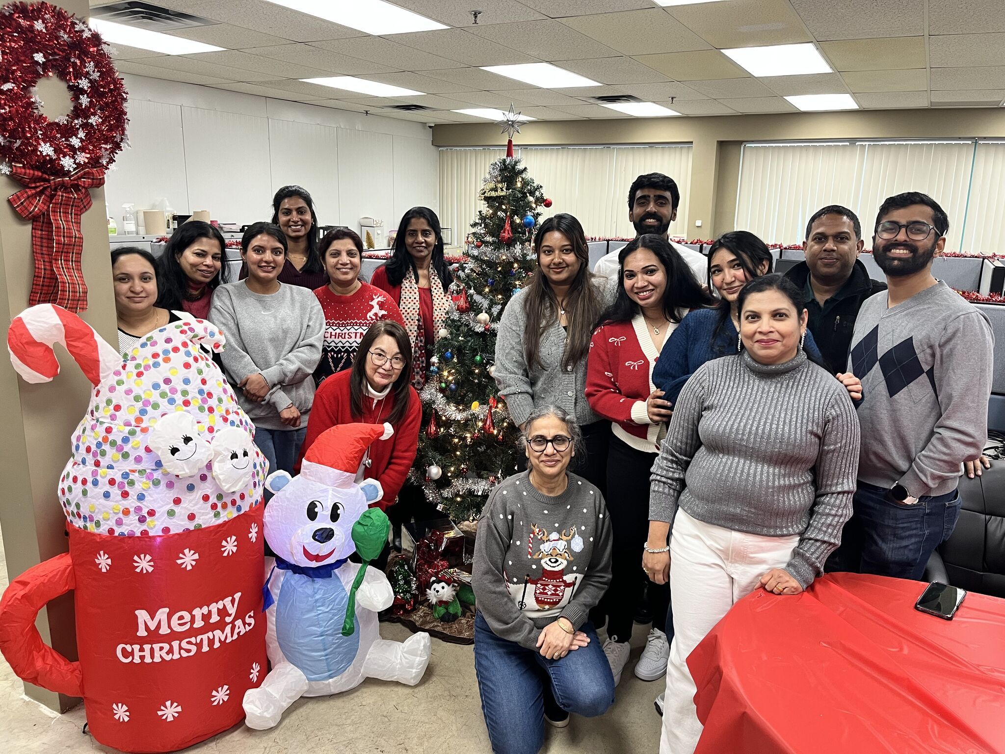 Group of people celebrating Christmas with decorations and a Christmas tree.