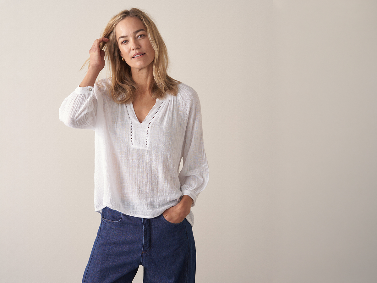 Woman wearing a white cotton top with blue denim trousers