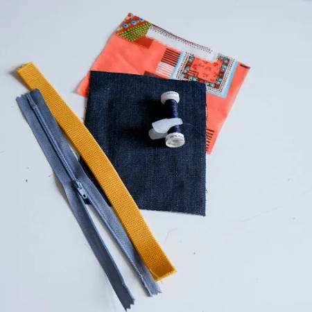 Two fabric pieces, matching thread, a piece of elastic and a zipper to make a wrist pouch