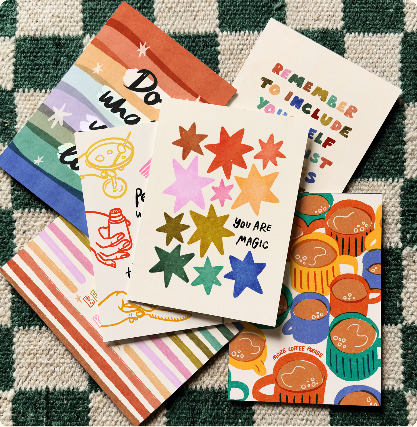 Colorful postcards with various designs on a checkered green background.