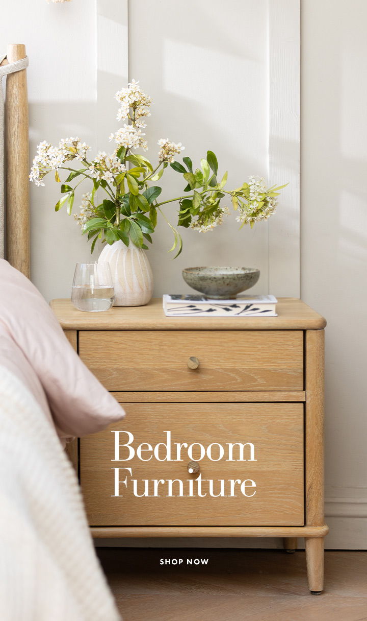 A bedside table with flowers and a bowl, labelled 