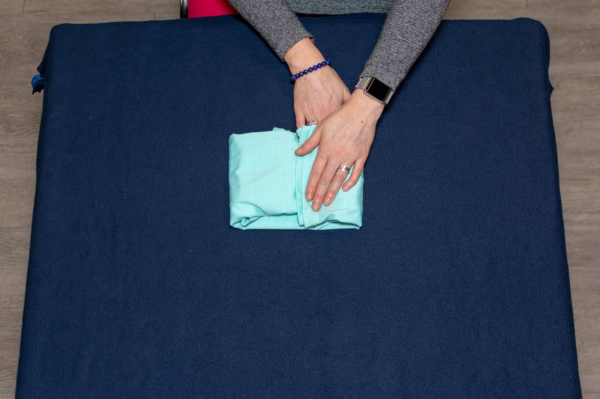 hands folding long-sleeved tee