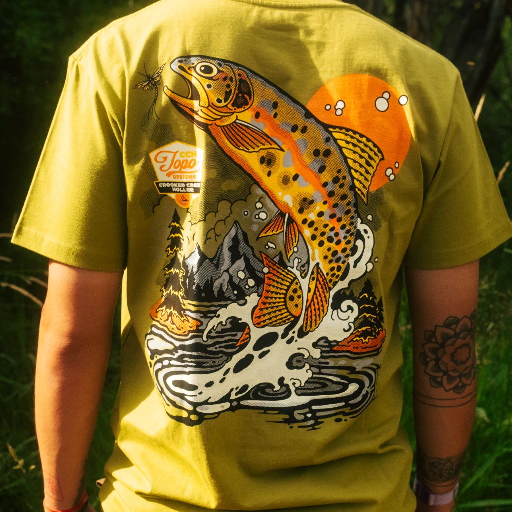 Person wearing a yellow shirt with a colorful fish design on the back.
