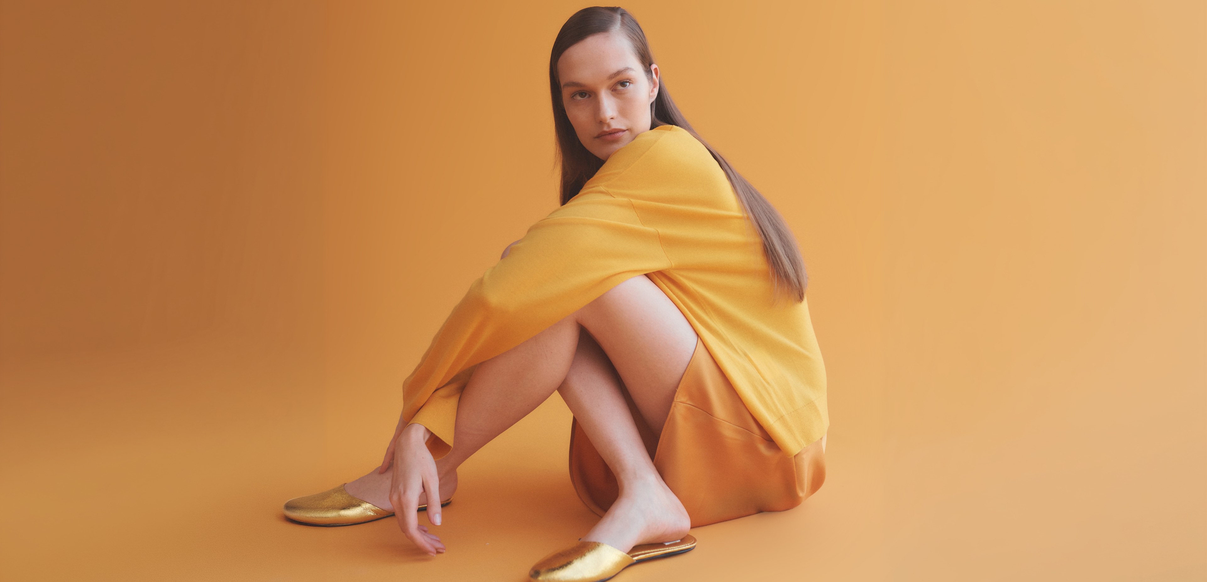 Woman sitting on ground with legs crossed