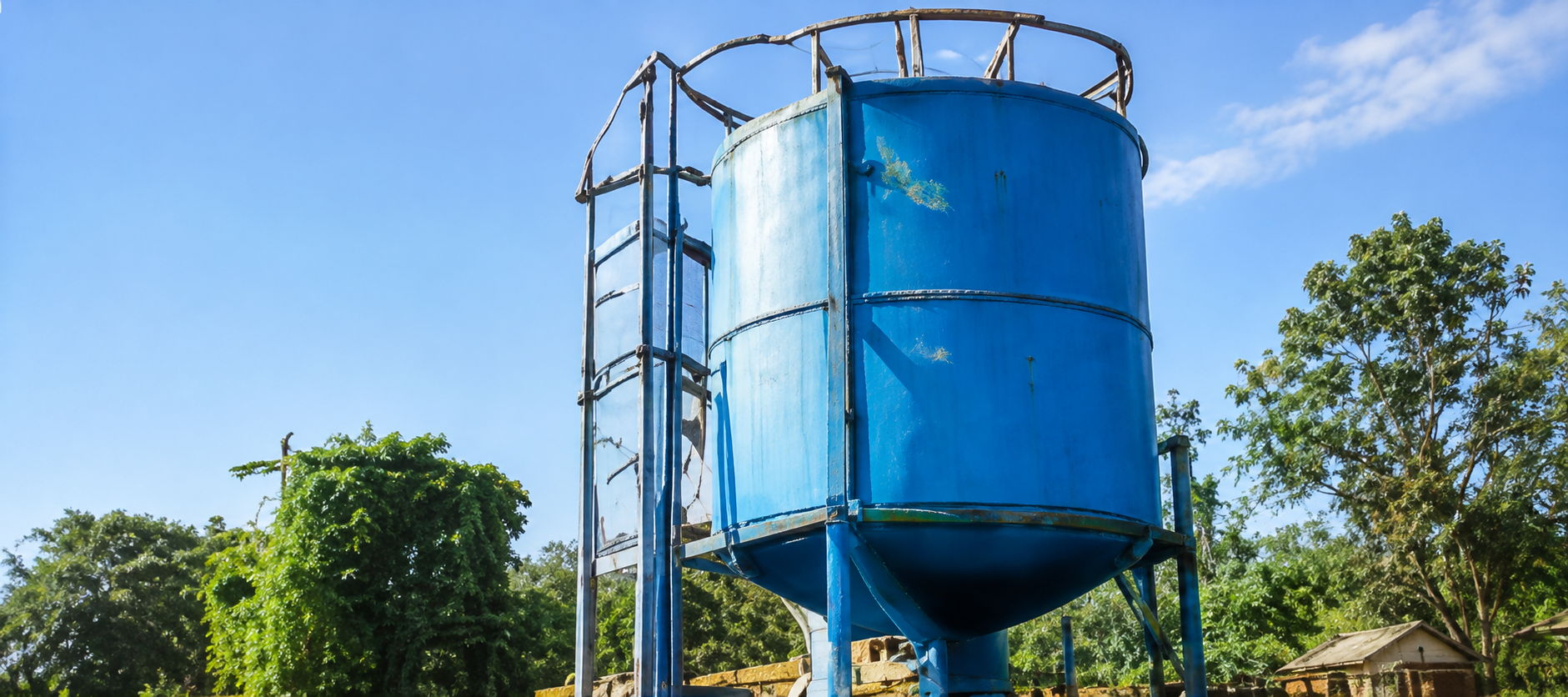 A tall blue water tank against a clear blue sky.