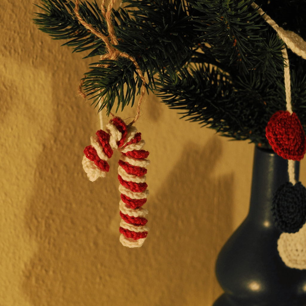Gehäkelte Zuckerstange aus weißem und rotem Garn.