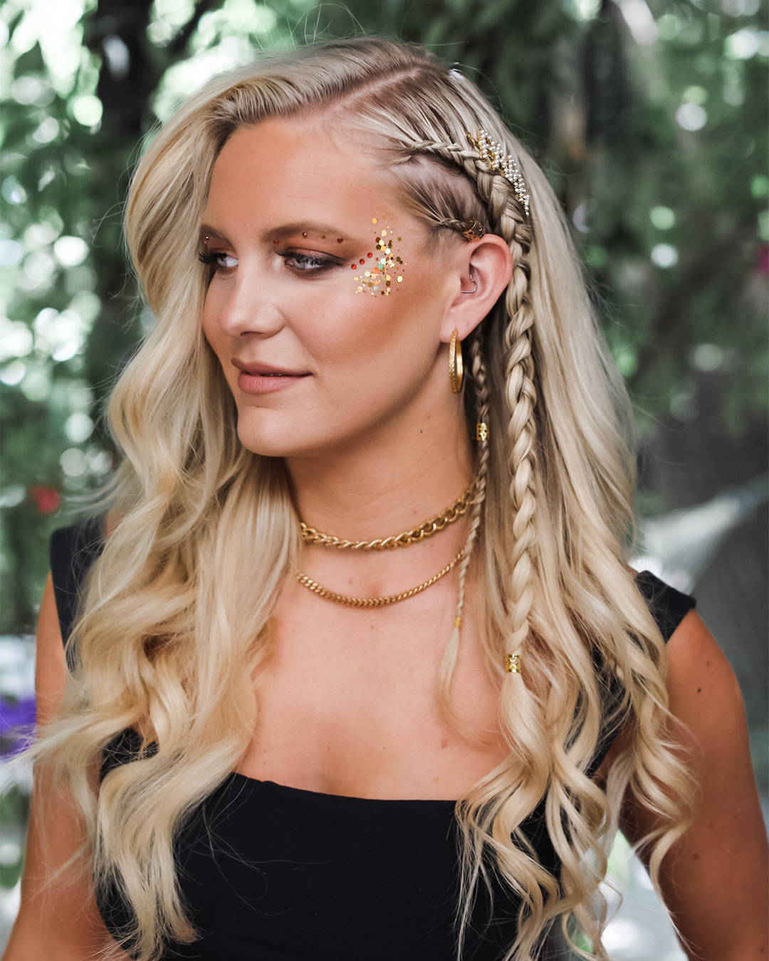 Image of Model with blonde beachwaves and glowy makeup  posing showing off her festival braid 