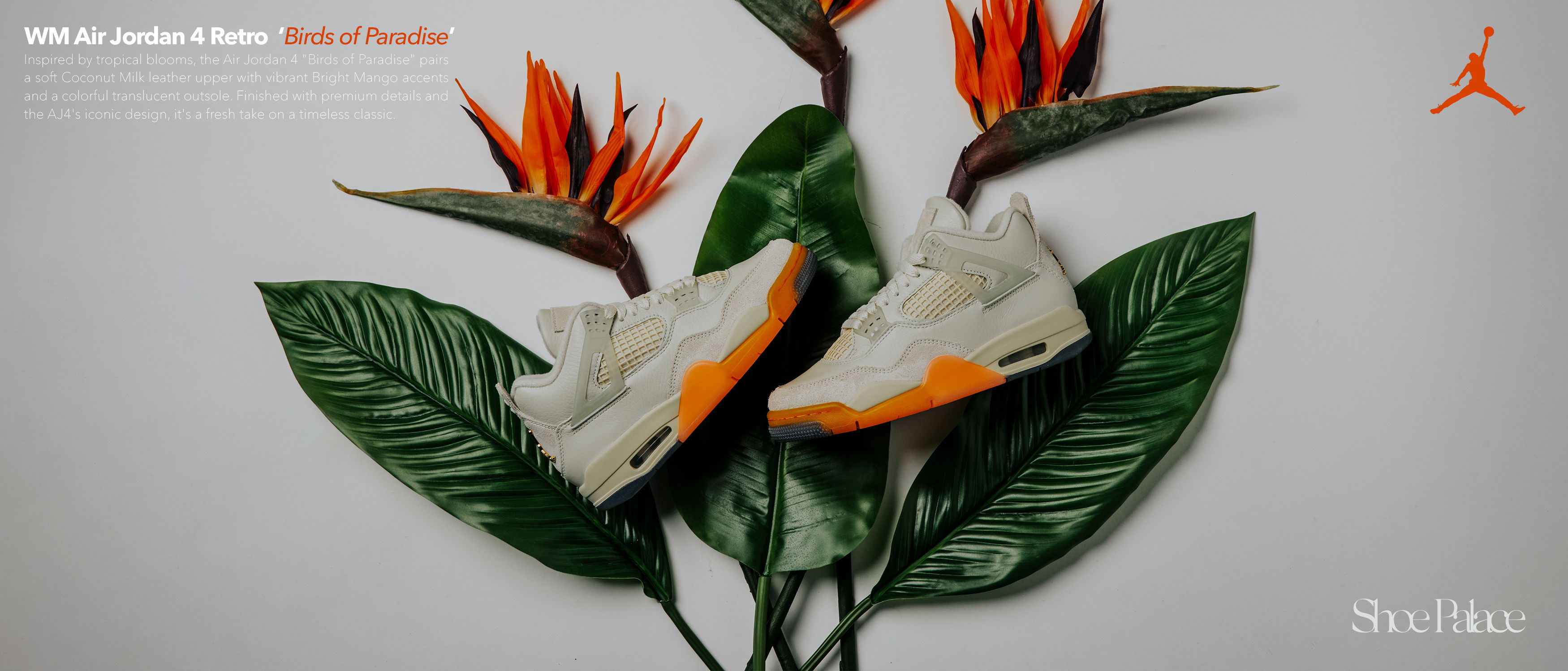 Sneakers placed on leaves with tropical flowers in the background.