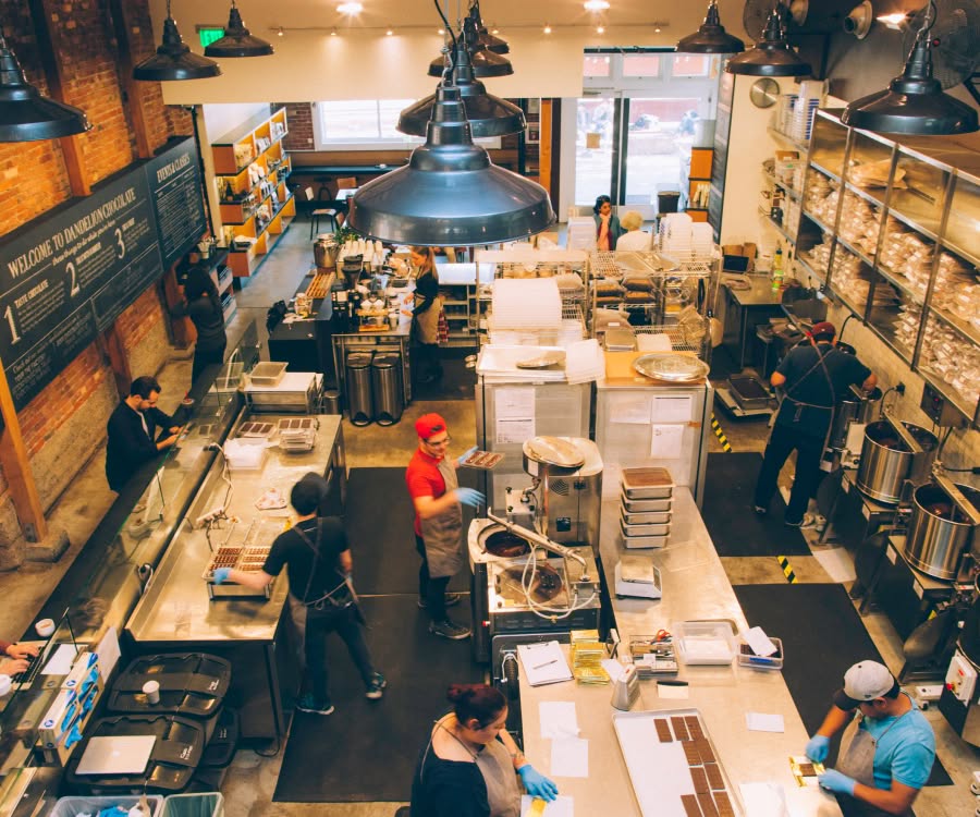 A busy café interior with staff and customers engaging in activities.