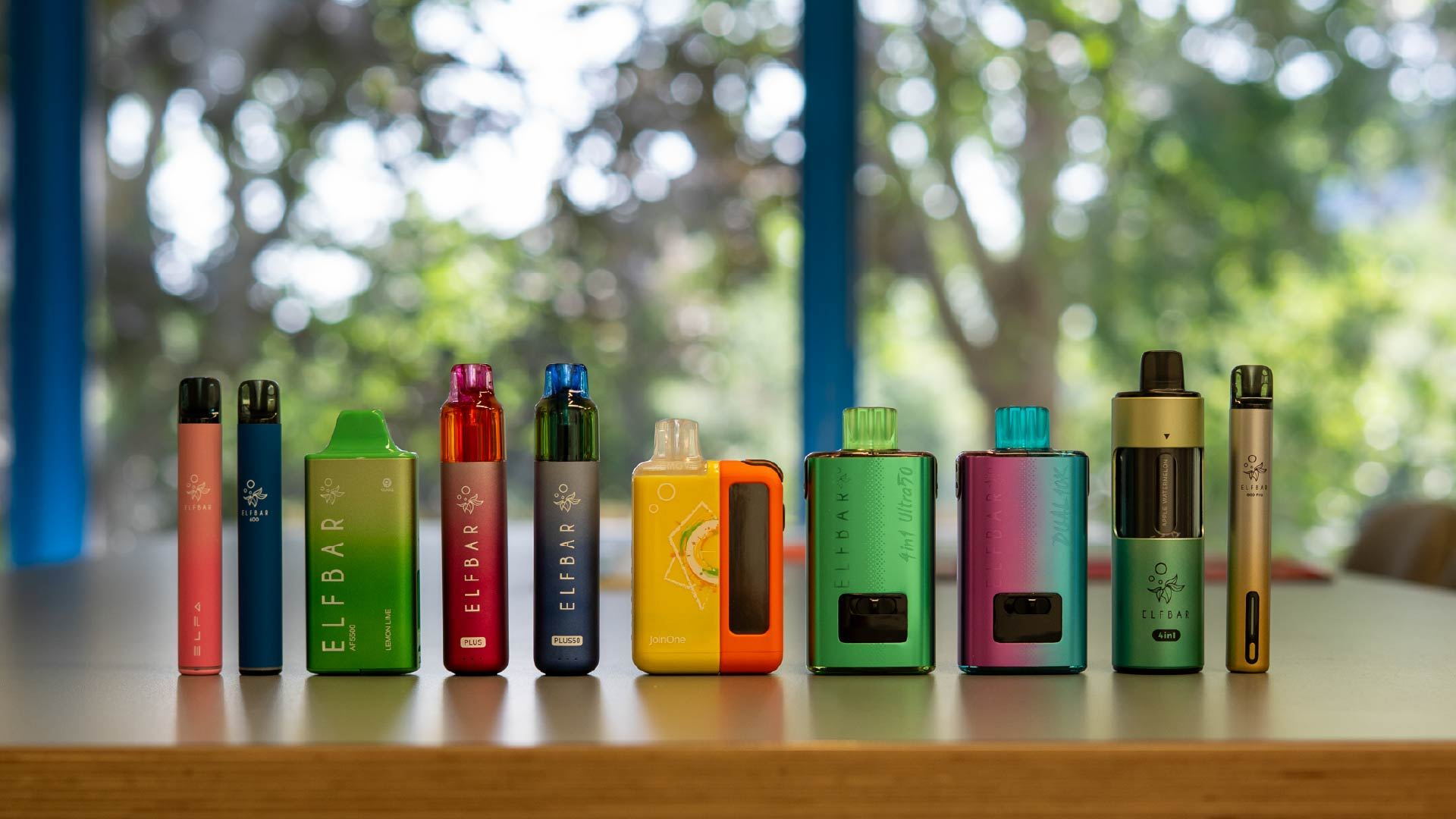 A row of colorful vape devices on a table.