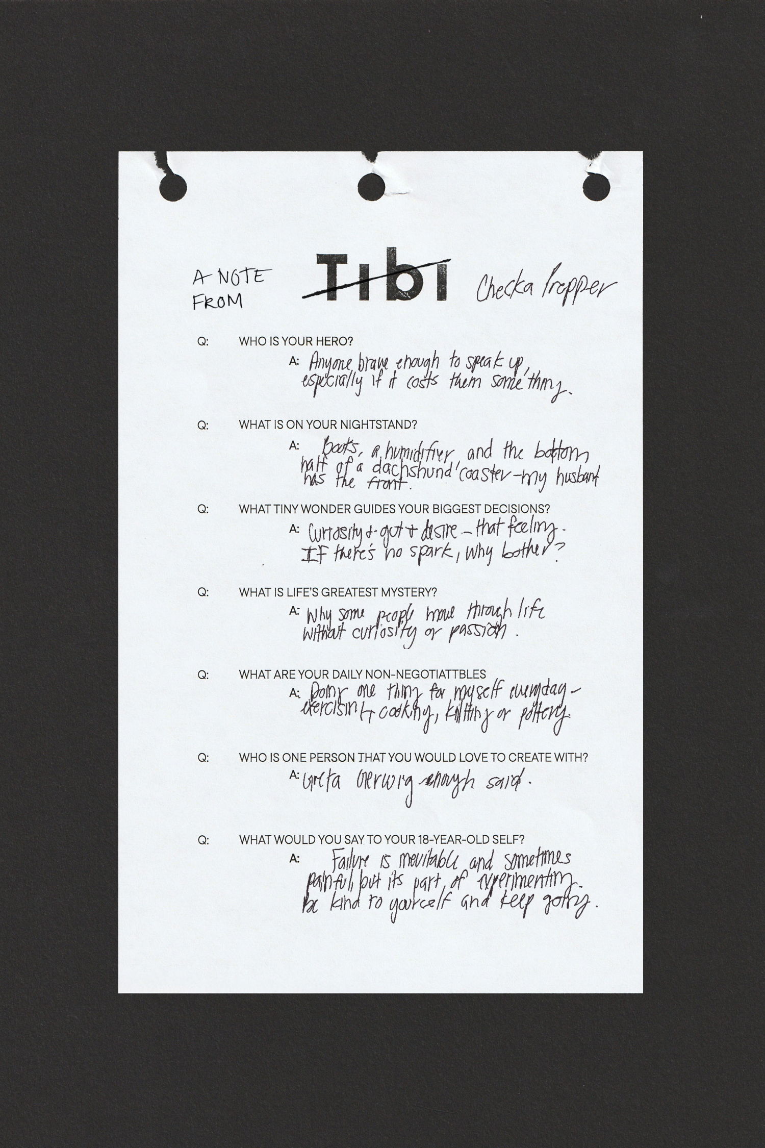 Handwritten note on a torn sheet of paper with black background.