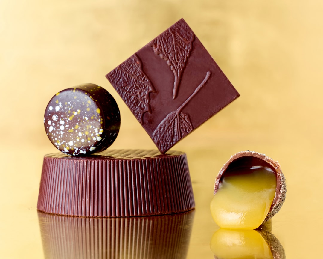 Assorted chocolates on a golden background.