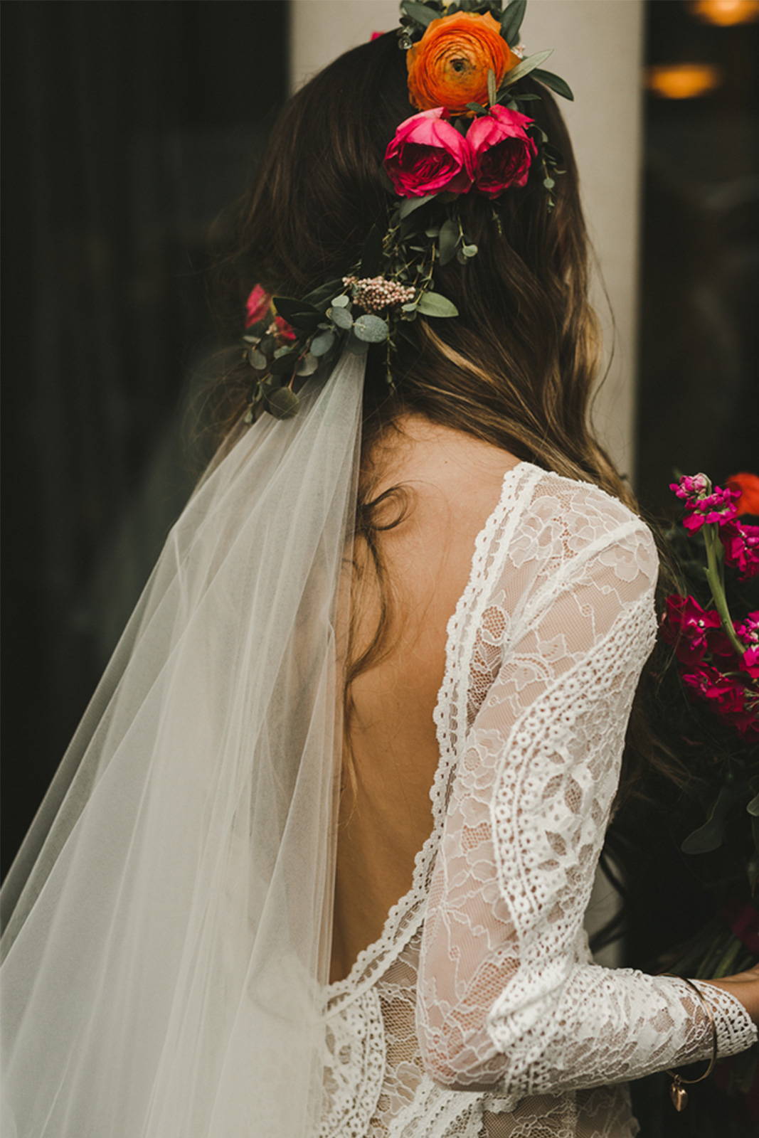Bride in low back lace dress with flowers in hair