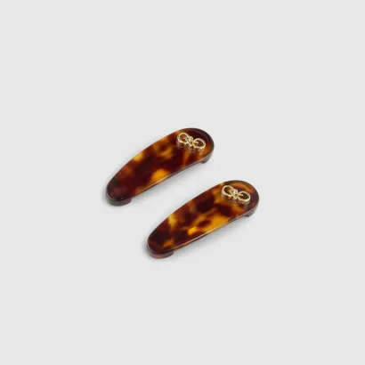 Two tortoiseshell hair clips with gold accents.