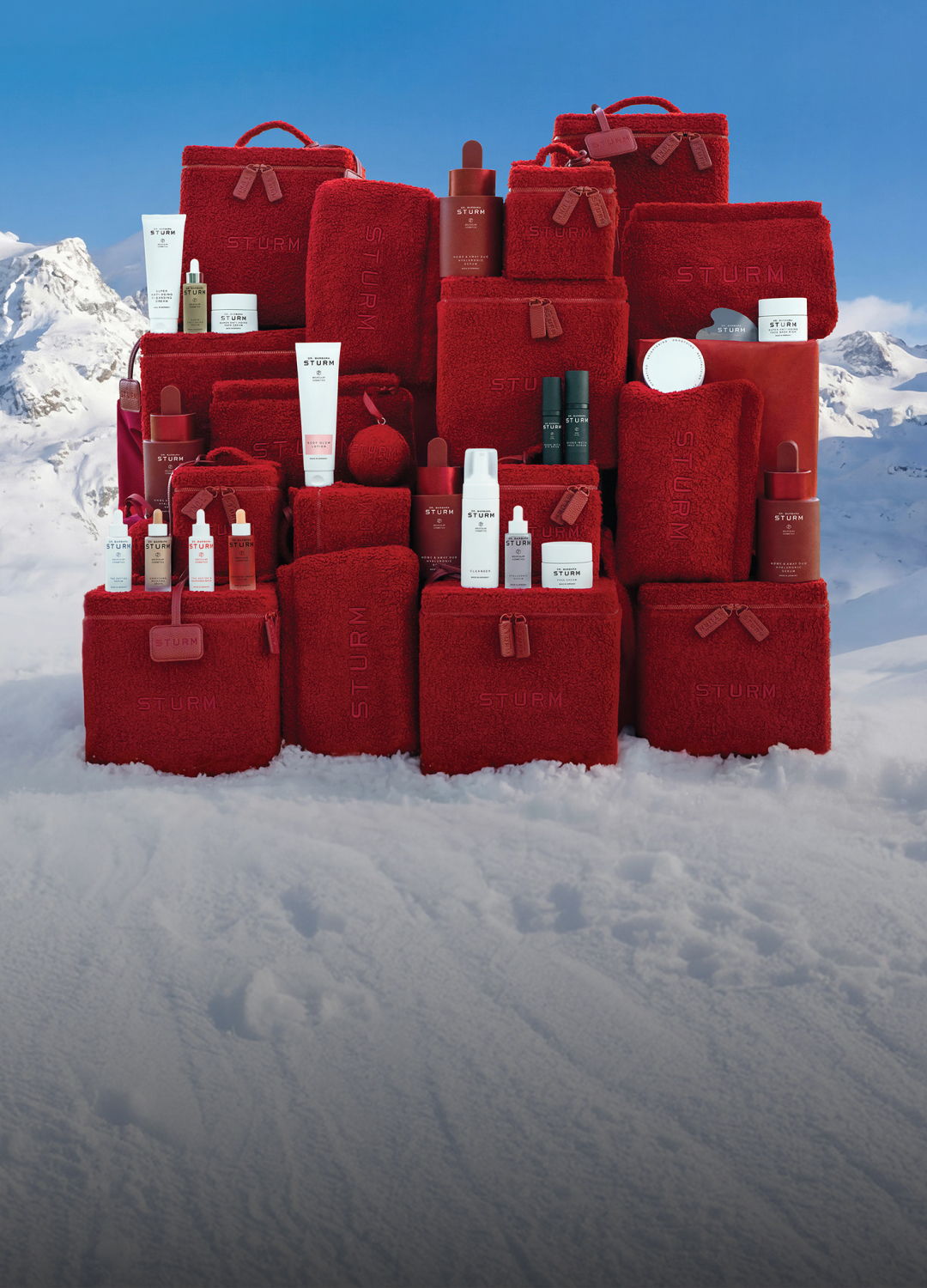A collection of red bags and skincare products on a snowy background.
