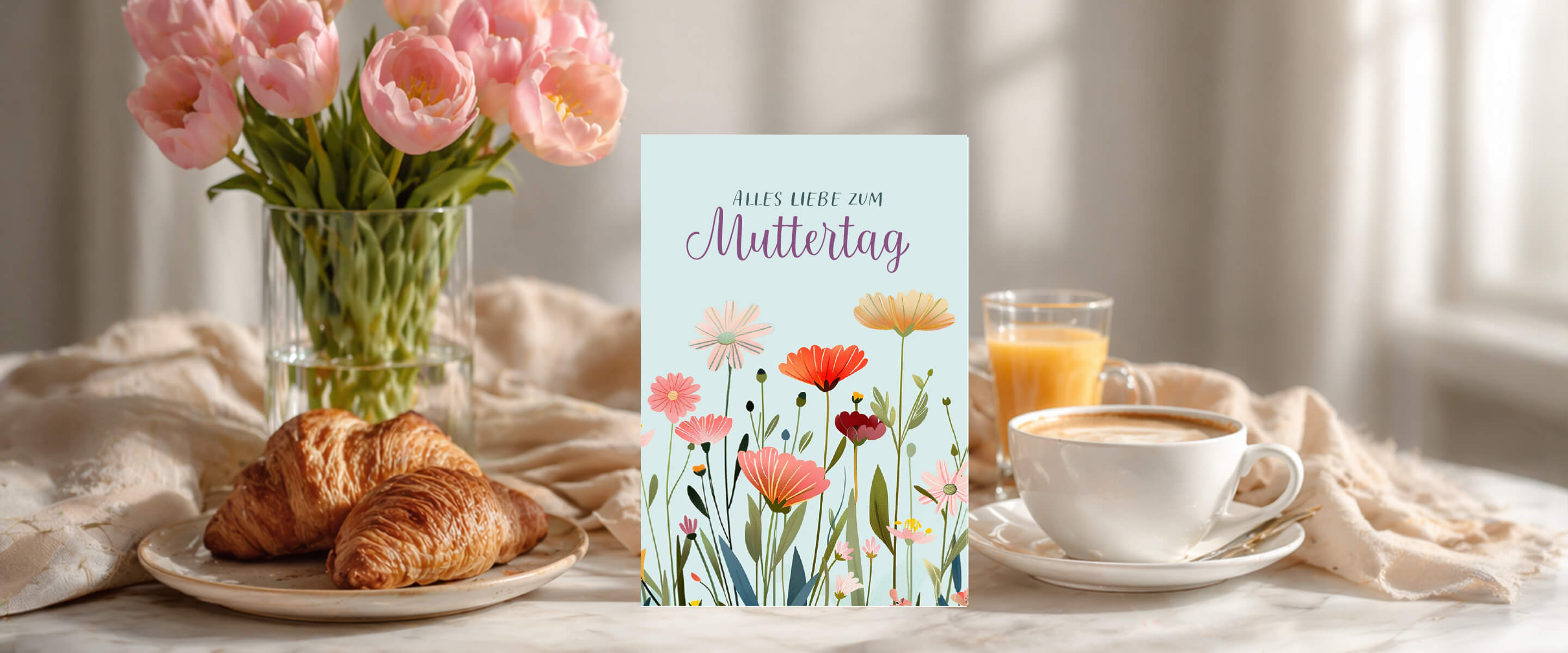 A cozy breakfast setting with flowers, pastries, and a greeting card.