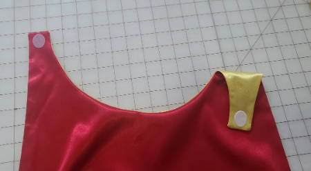 Attach Velcro to the tabs on opposite sides of the cape so that the tabs overlap when connected. I used some adhesive Velcro circles that were designed for fabric. All you do is peel off the backing and stick them where you want.