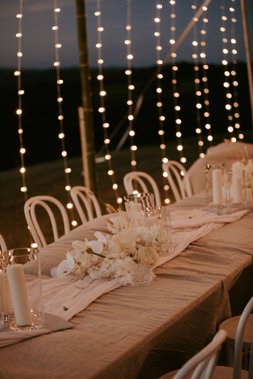 Linen tablecloth dining table underneath the fairy lights