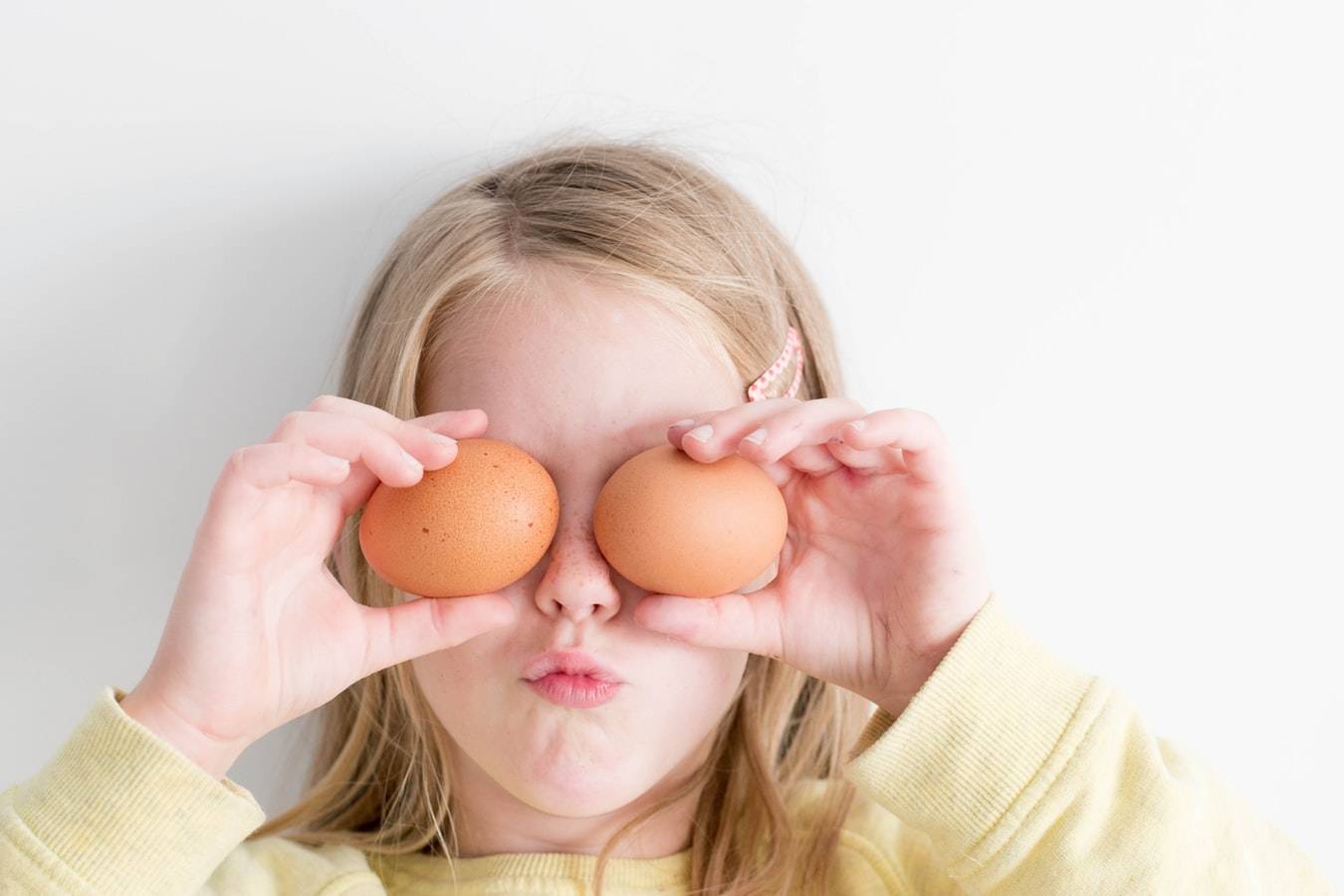 Child With Eggs Covering Their Eyes