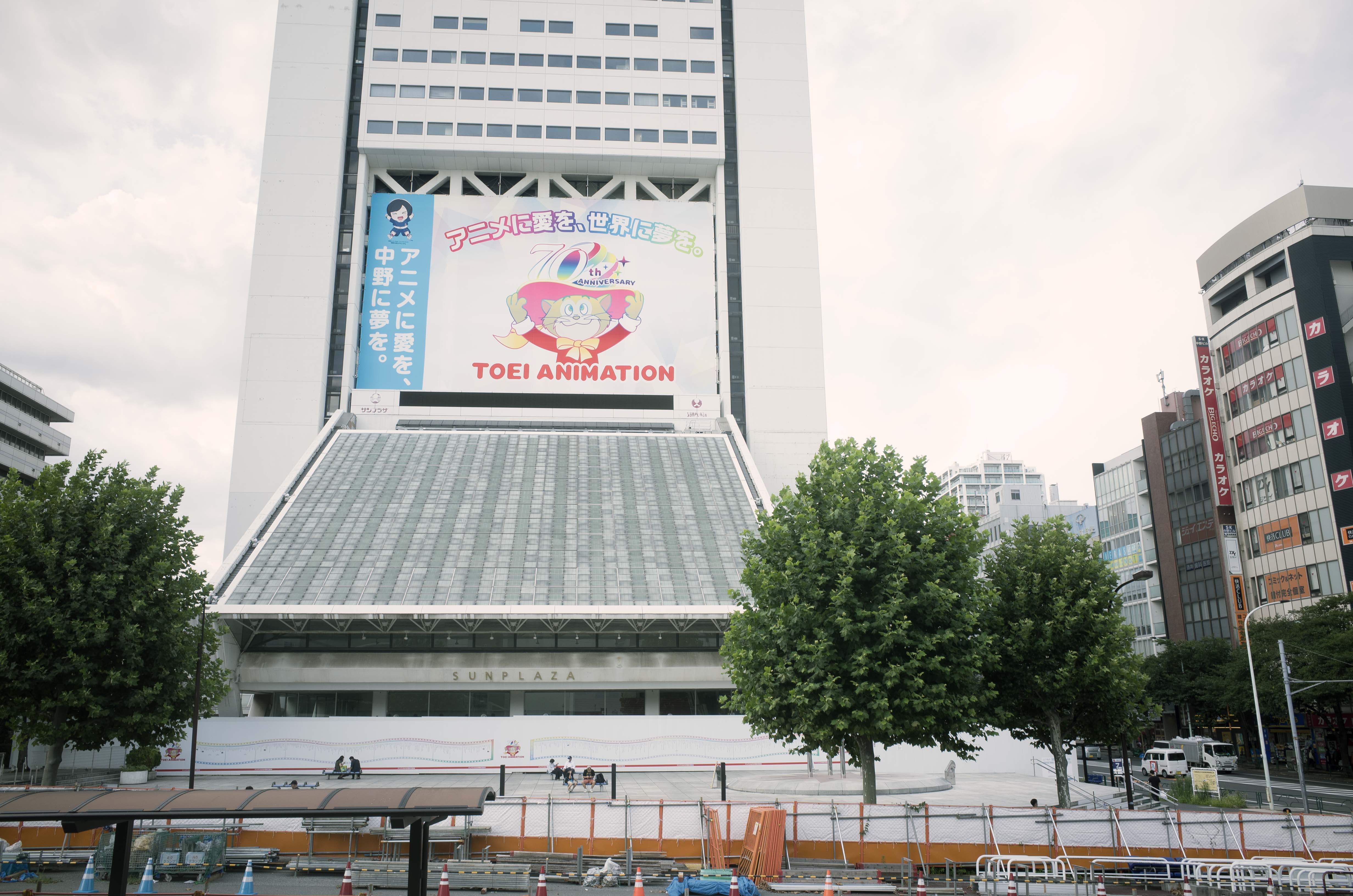 Building with a large banner, trees, and construction in the foreground.