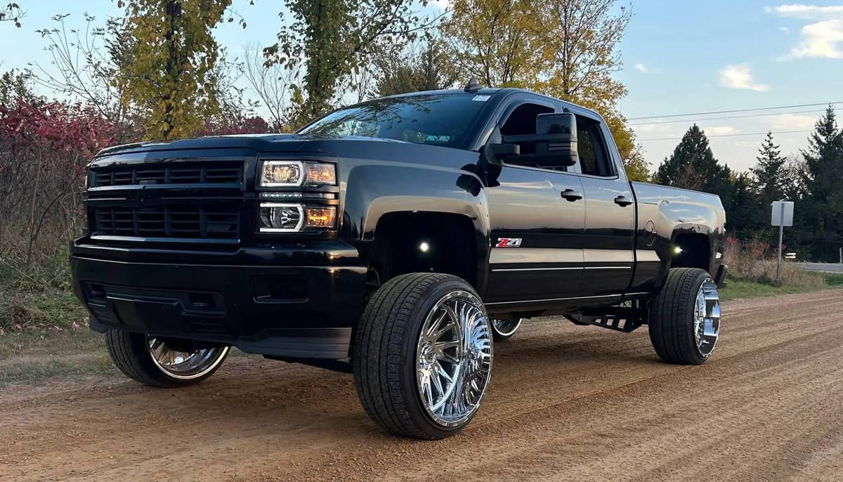High-angle three-quarter front view of Conner's lifted black 2015 Chevy Silverado 1500 Z71 with HornBlasters Conductor's Special 232 Spare Tire Delete kit featured customer install gallery photo 1