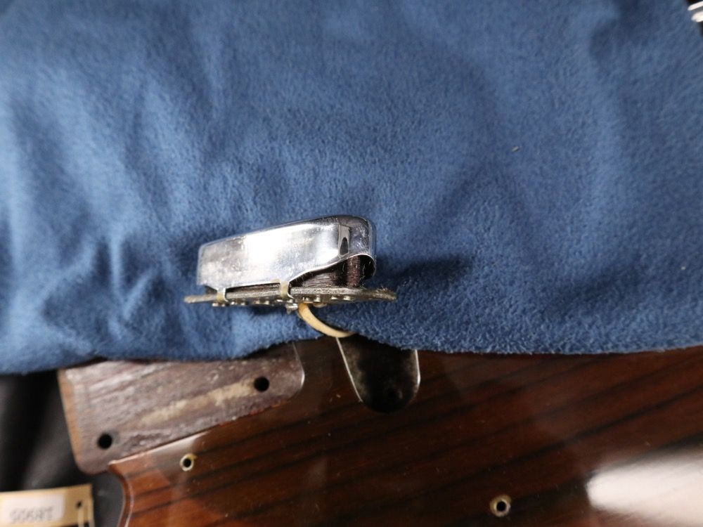 Close-up of a metallic object resting on blue fabric.