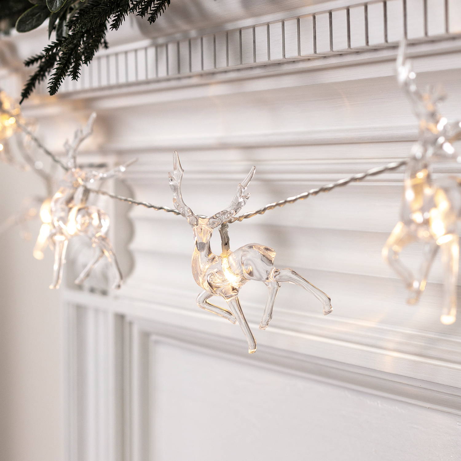 Reindeer battery Christmas fairy lights draped over a  mantle piece