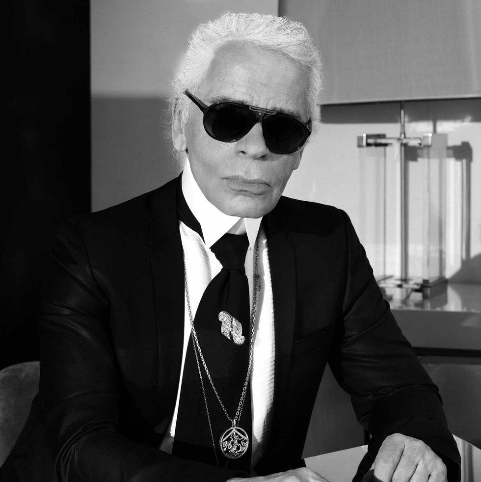 Le regretté Karl Lagerfeld portait des lunettes de soleil aviateur emblématiques en photo noir et blanc avec un long collier, une chemise blanche et une veste noire