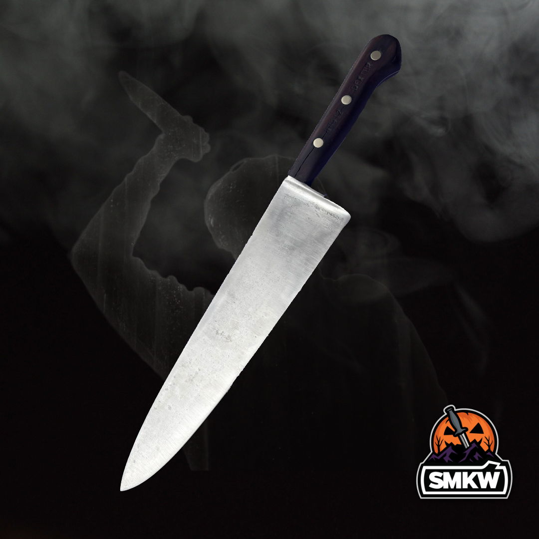 A sharp kitchen knife with a black handle against a smoky background.