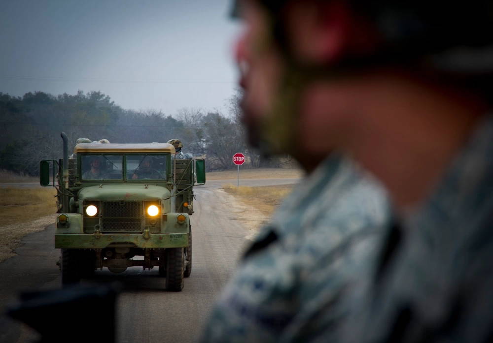 Staff SSgts. Jason Gavin and Adam Wheeler ride on the back of an M35 2.5-ton cargo truck traveling to the firing range, Jan. 14, as part of the Combat Leadership Course here. Gavin is a flight chief from the 81st Security Forces Squadron, Keesler Air Force Base, Miss., while Wheeler is a corrections officer at Marine Corps Air Station Miramar, Calif.