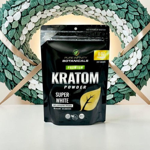 Black pouch of Kratom powder with a leaf design on a light background.