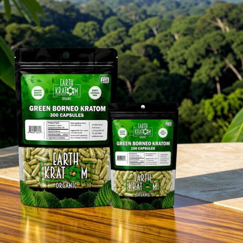 Bags of Green Borneo Kratom capsules on a wooden surface with greenery background.