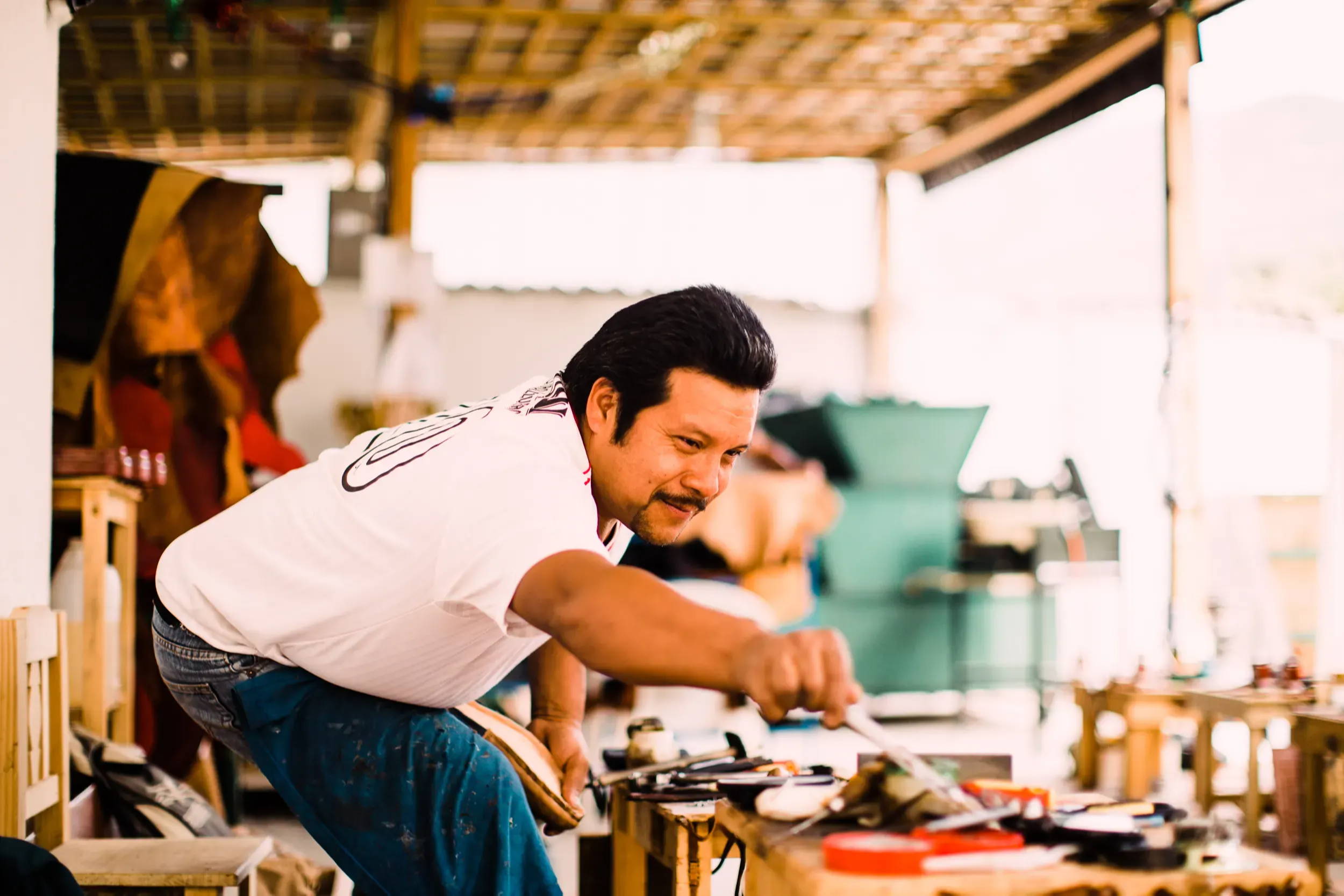 Adelante craftsman smiling and making shoes